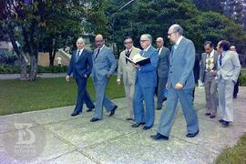 Mário Augusto Jorge de Castro Lima (Ministro da Saúde), observando livro enquanto caminha pela al...