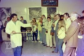 [Comemoração dos 90 anos do Instituto Butantan]. Técnico manuseando serpente para visitantes