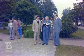 Mário Augusto Jorge de Castro Lima (Ministro da Saúde), observando livro próximo ao monumento com...