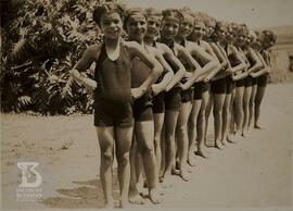 fotografia em grupo de alunas do Grupo Escolar Butantan enfileiradas  com roupas de natação. A pr...