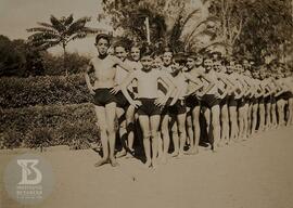 fotografia em grupo de alunos do Grupo Escolar Butantan enfileirados  com roupas de natação. Da e...