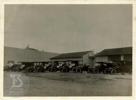 [Veículos do Desinfectório Central estacionados na parte de trás do prédio e funcionários]